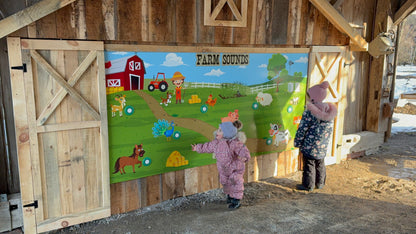 Guests interacting with heemer crafted barnyard sound board, smiling.